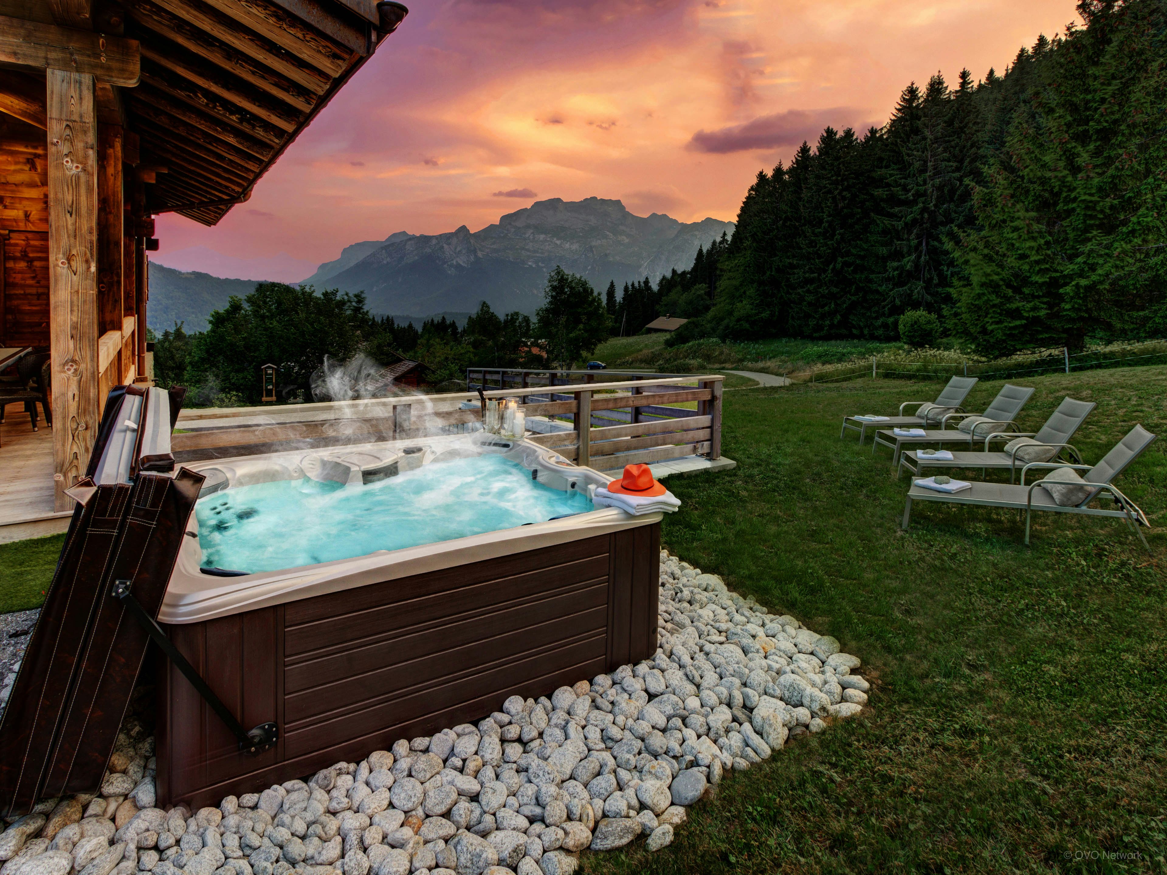 The hot tub in the garden at sunset at Chalet Pralor Le Nova. 