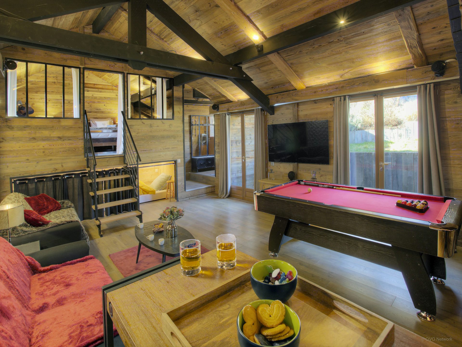 chalet-kalyssia-stylish-living-space-with-pool-table-tv-and-stairs-to-bedroom