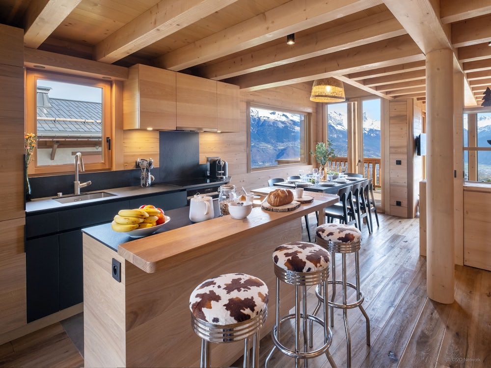 The kitchen with a breakfast bar and stools at Chalet Fanfoua